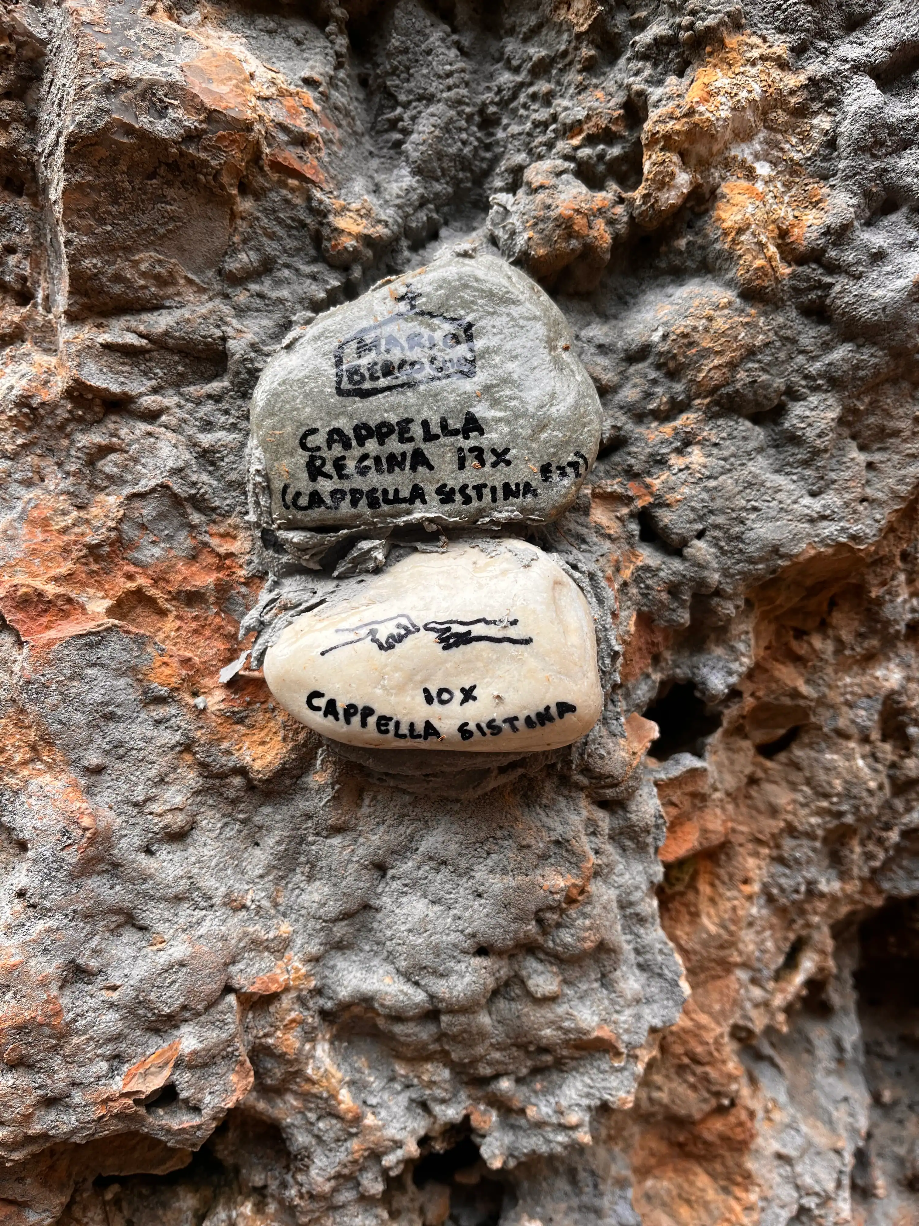 Custom route stones designating each climbing route at sector Capella